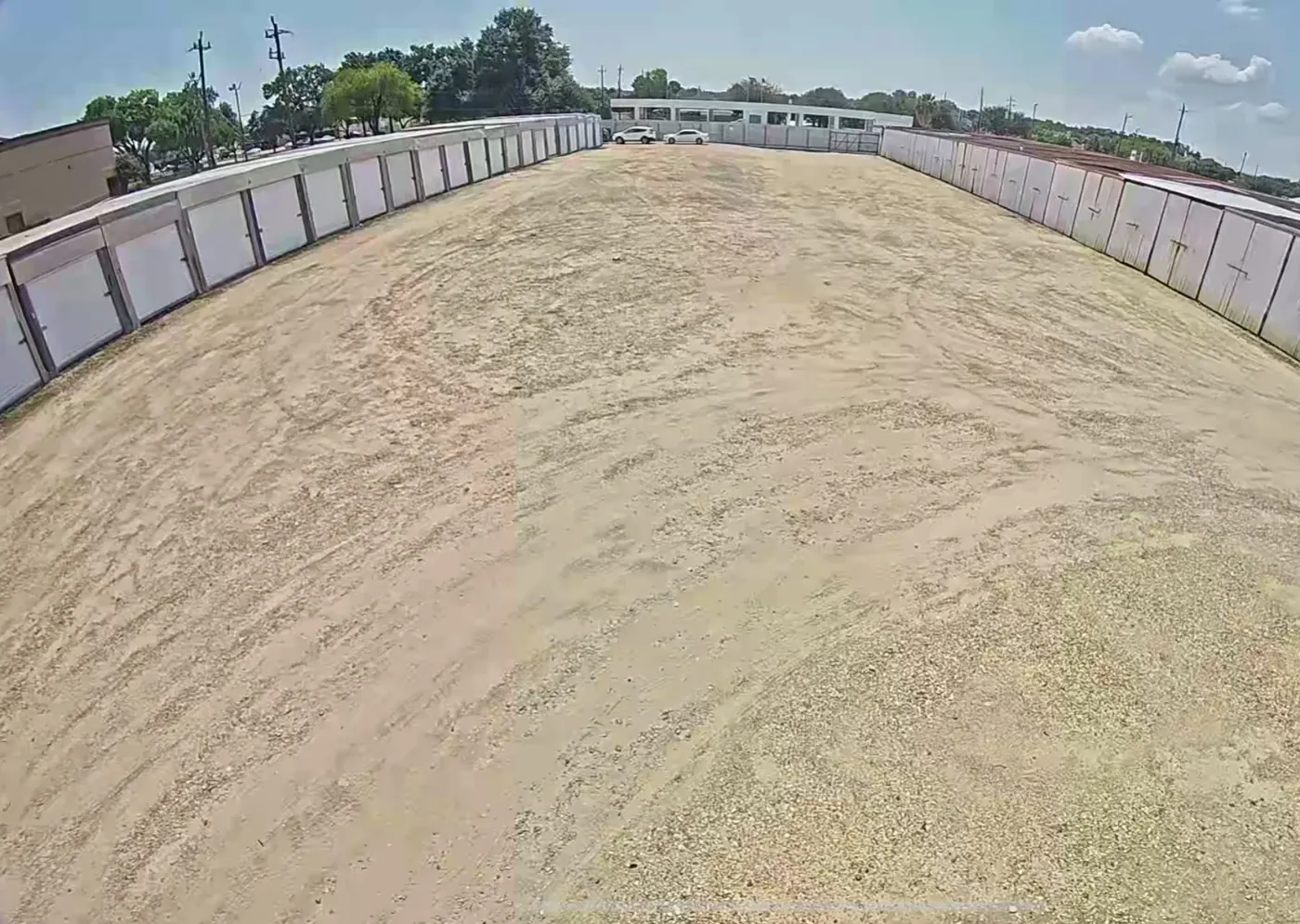 Open parking lot lined with storage stalls at Almeda Genoa Storage